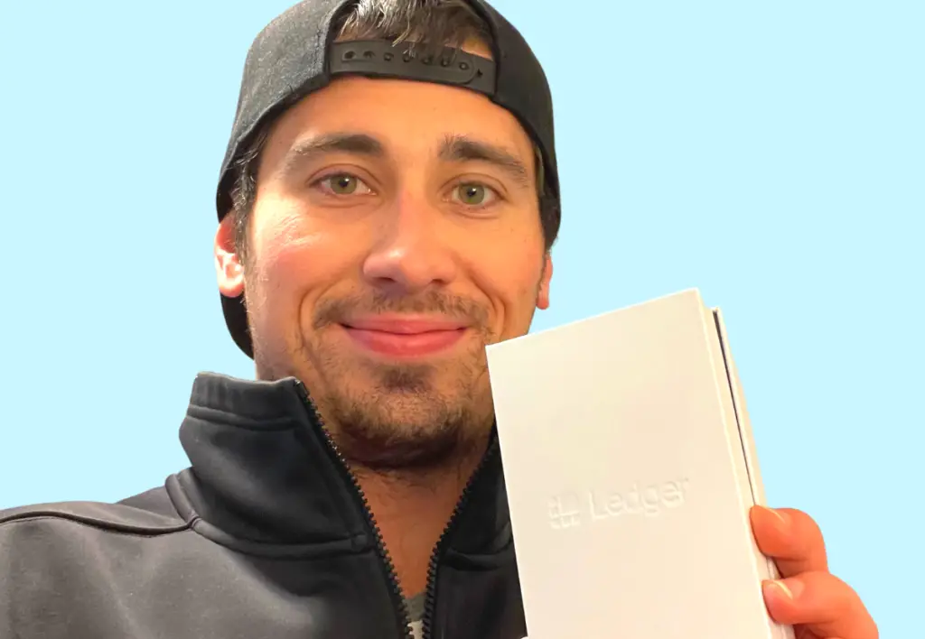 Alex Gomez holding his Ledger Nano X wallet.