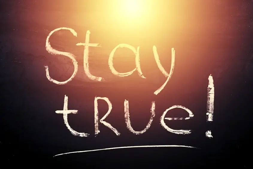 NFT artists need to stay true to themselves. A chalkboard with the words stay true on it.