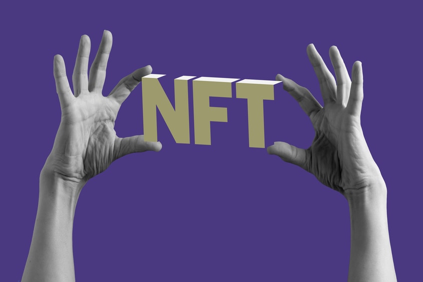 NFT. Two hands holding up a non-fungible token (NFT).